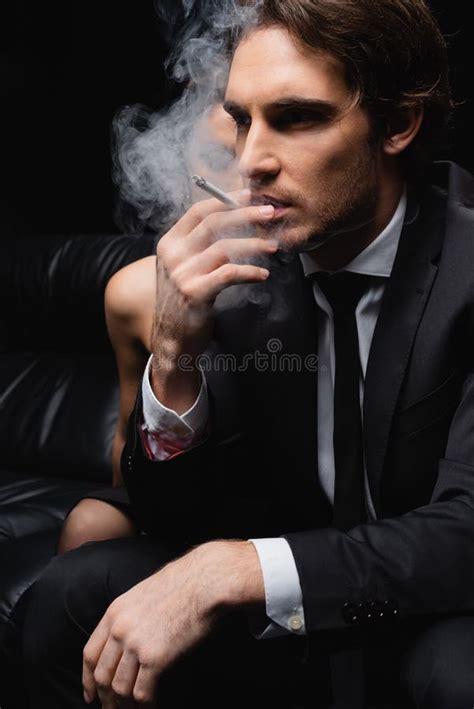 men in suits smoking cigarette.